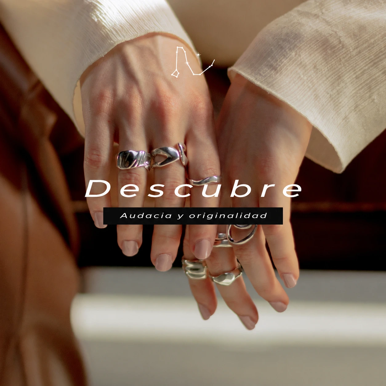 Campaña Draco: Descubre. Audacia y originalidad. Manos con anillos y chaqueta clara